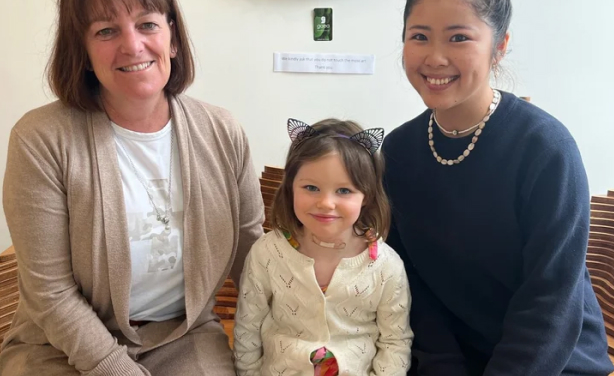 黒いスーツを着た7人のスタッフが並んで笑顔で写っている集合写真