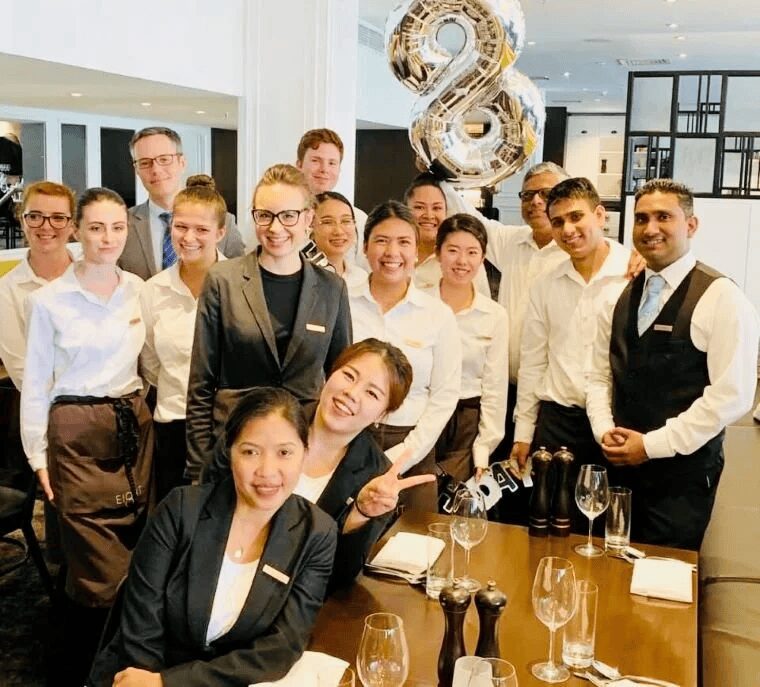 レストランのスタッフが集まって笑顔で記念撮影している写真